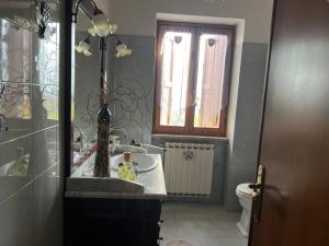 baño con lavabo y aseo y ventana en Villa Pampaloni - Villa vacanze con Buffet di benvenuto, en Fabrica di Roma