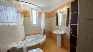 a bathroom with a tub and a sink and a toilet at Ismini Luxury Villa in vlicha
