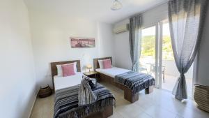 a bedroom with two beds and a balcony at Ismini Luxury Villa in vlicha