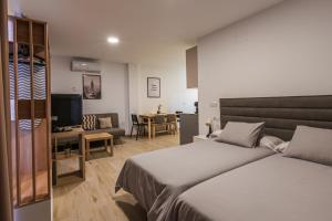 Un dormitorio con una cama, un escritorio y un televisor. en Apartamentos Turisticos José Cruz, en Nerja 66 fotos más