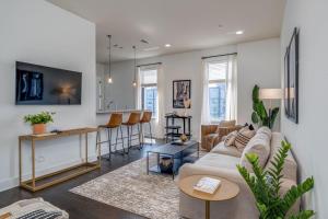 a living room with a couch and a table and a kitchen at LOFTS AT 30TH - MODERN LOFT - MINS TO BROADWAY in Nashville