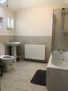 une salle de bain avec un lavabo, une douche et des toilettes dans l'établissement Sleeps 10 5 bedroom town house 3 miles from Zip World, à Blaenau Ffestiniog