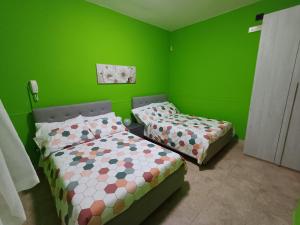 two beds in a room with green walls at Sotto Li Foj in Picerno