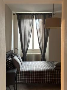 een slaapkamer met een bed en een raam met gordijnen bij Holiday Home Curt de l'Elba with private garden and parking - Cernobbio in Cernobbio