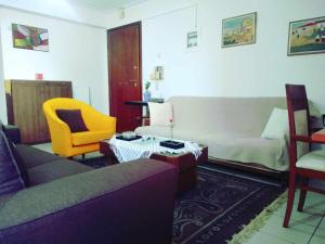 sala de estar con sofá y silla amarilla en Betty's sunny apartment-Athens, en Atenas
