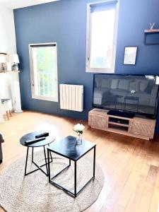 a blue living room with a table and a coffee table at Le Rabelais, superbe appartement en duplex, proche forteresse et monument historique in Chinon