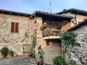 Casa de piedra con balcón y macetas en Agriturismo Fattoio alle Ripe, en Pelago