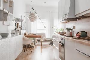 cocina con armarios blancos y comedor en Modern and centrally located 2-Bedroom apartment en Bergen