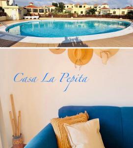 a living room with a blue couch and a swimming pool at Casa La Pepita in Caleta De Fuste