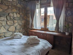 的住宿－Kompleks Etno Luks，石墙卧室设有一张床和一个窗户
