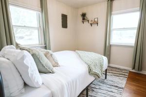 un divano bianco in soggiorno con due finestre di Heart Of Boise Cozy & Fast Wifi Near Top Attr a Boise