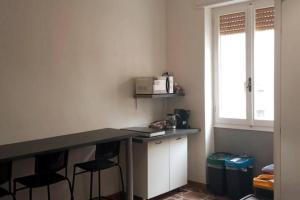 a kitchen with a counter with stools and a microwave at PORRINO Guest House - Affittacamere in Alghero