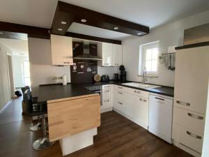 a kitchen with white cabinets and a black counter top at Ferienhaus Thomsen in Epenwöhrden