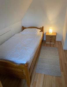 a bedroom with a bed and a night stand with a lamp at Ferienhaus Thomsen in Epenwöhrden