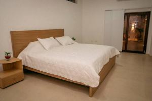 1 dormitorio con 1 cama grande y cabecero de madera en Casa de descanso cerca al cañon del Güejar, en Granada