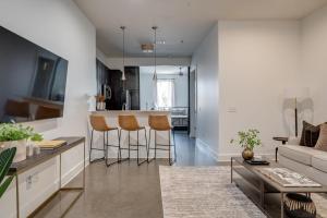 a kitchen and living room with a couch and a table at Lofts At 30th - Modern Life - Mins To Broadway in Nashville