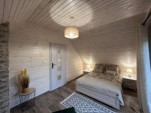 a bedroom with a bed and a wooden ceiling at Willa pod Dębami domek nad Zalewem Chańcza z balią na wyłączność in Raków