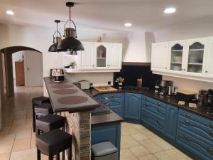 eine blaue Küche mit weißen Schränken und einer Arbeitsplatte in der Unterkunft La Grange Sud in Turnac