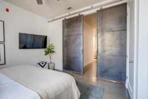 1 dormitorio con 1 cama y puerta corredera de cristal en Lofts At 30th - Modern Life - Mins To Broadway en Nashville