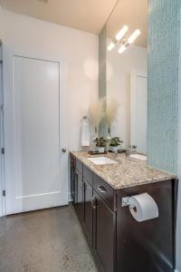 baño con 2 lavabos y espejo grande en Lofts At 30th - Modern Life - Mins To Broadway en Nashville