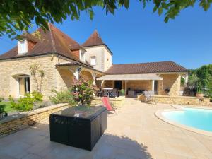 ein Haus mit Swimmingpool und Terrasse in der Unterkunft La Grange Sud in Turnac