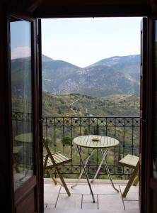 a table and chairs on a balcony with a view at Chrysanthemo House in Arachova