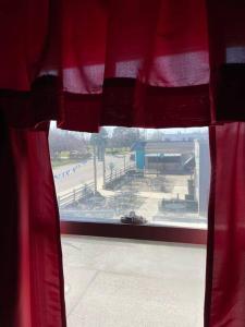 Blick auf einen Spielplatz aus einem Fenster mit roten Vorhängen in der Unterkunft Actual Pretty Boy Floyd's Hideout - Lake Erie, MI in Luna Pier
