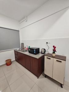 eine Küche mit einer Theke mit einer Spüle und einem Kühlschrank in der Unterkunft Bayu Temiang Residence - Eco Friendly Retreat in Seremban