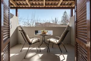 a patio with a table and chairs on a balcony at Santa Maroma Rooms & Houses in Vasilikos