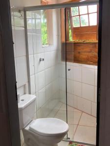 a bathroom with a toilet and a glass shower at Espaço Circular in Itacaré