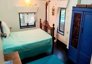 a bedroom with a bed and a blue cabinet at The Patnem villa in Canacona