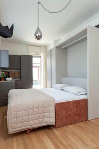 a bedroom with a large bed and a kitchen at art of design & terrace in Milan