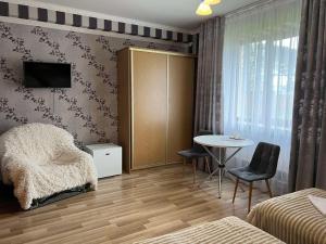 ein Schlafzimmer mit einem Tisch und einem Bett sowie einem Tisch und Stühlen in der Unterkunft Mini-Hotel "Nord" in Chynadiyovo
