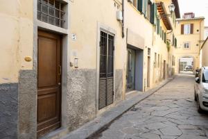 un vicolo con una porta e auto parcheggiate in strada di Ardiglione Flat a Firenze