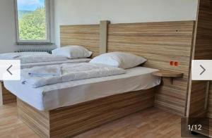 Dos camas en una habitación con dos flechas apuntando a en Tacidur Home, en Tuttlingen