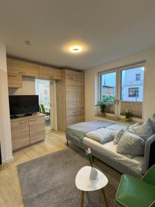 a bedroom with a bed and a tv and a couch at Near Holstentor modern apartment near the center with wifi in Lübeck