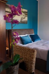 1 dormitorio con 1 cama y un jarrón con flores púrpuras en La Dolce Vita, en Regalbuto