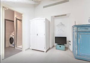 een woonkamer met een tv en een blauwe kast bij Conte Verde in Turijn