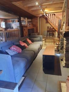 ein Wohnzimmer mit einem blauen Sofa und einem Tisch in der Unterkunft La grange des Quatre saisons in Gouaux-de-Luchon