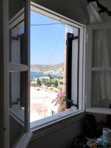 una ventana abierta con vistas al océano en Orantes Maris Luxury en Katapola