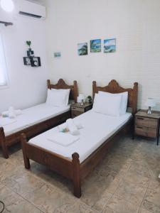 two beds in a room with two tables at Orantes Maris Luxury in Katapola