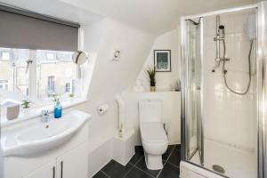 ein Bad mit einem WC, einem Waschbecken und einer Dusche in der Unterkunft Bright Fitzrovia Studio in London