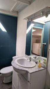 a bathroom with a sink and a toilet and a mirror at La petite Glycine in Sérignan