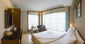 a hotel room with a bed and a television at Hotel Casa Fortuna in Kolkata