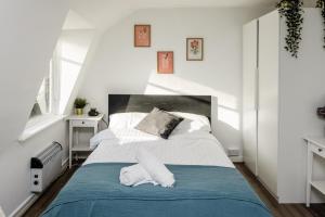 a bedroom with a large bed with a blue blanket at Bright Fitzrovia Studio in London
