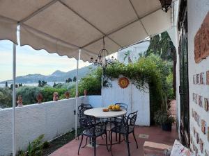 einen Tisch und Stühle unter einem Sonnenschirm auf einer Terrasse in der Unterkunft Jasmine in Letojanni