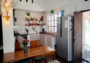 a kitchen with a wooden table and a refrigerator at The Patnem villa in Canacona