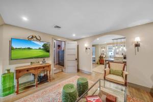Una sala de estar con un televisor, un sofá y una mesa. en Luxury Loft in Historic Carriage House, en Kennett Square