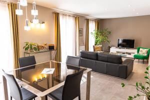 uma sala de estar com uma mesa de vidro e um sofá em Les Tournesols em Saint-Martin-de-Crau