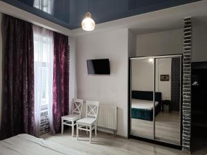 リヴィウにあるApartments Zefir on Vynnychenkaのベッドルーム1室(鏡、椅子2脚、ベッド1台付)